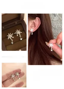 Macro shot of silver fireworks star earrings with cubic zirconia and hanging charms