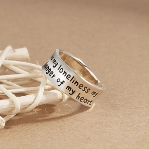 Engraved silver open ring with 'my loneliness' text on an aesthetic woven background