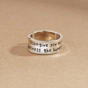 Minimalist silver open ring featuring artistic black letter engraving on textured paper