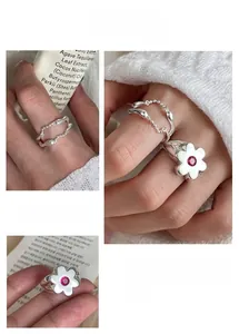 Detail of silver floral ring with red stone and double-layer beaded chain band