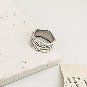 Detailed view of wide vintage silver ring with brushed finish and engraved lettering