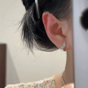 Elegant silver leaf huggie earrings with marquise-cut zircon stones on a female ear model