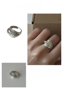 Detail of silver knot geometric open ring with hollow design and cool industrial style