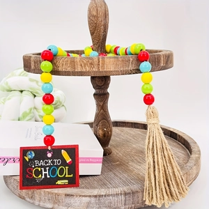 Detail of colorful wooden beads garland with Back to School chalkboard and hemp tassel