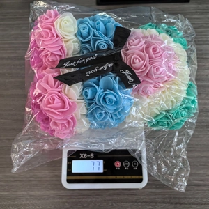 Detailed view of pink rose bear decoration on a digital scale showing weight