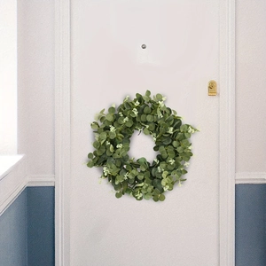 Close-up of artificial eucalyptus leaf wreath hanging on a white farmhouse door