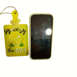 Close-up of lemon theme wooden tag and matte light yellow silicone phone case