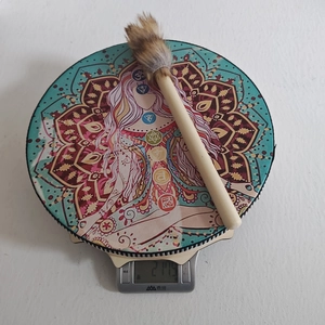 Detailed top view of a shamanic drum on a scale showing its 217.5g lightweight design