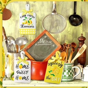 Three-piece lemon themed wood kitchen signs with ribbons and twine on a rustic counter