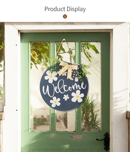 Detail of wooden welcome sign with daisies and plaid bow on a glass door