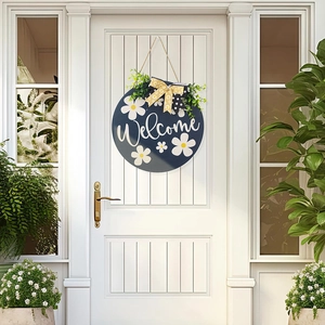 Detail of wooden welcome sign with white daisies and yellow bow on a white door