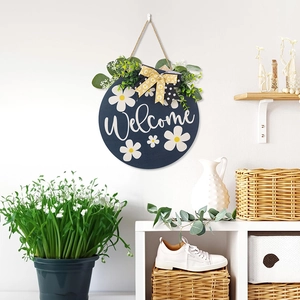 Detail of blue wooden welcome sign with daisy prints and yellow floral bow hanging on wall