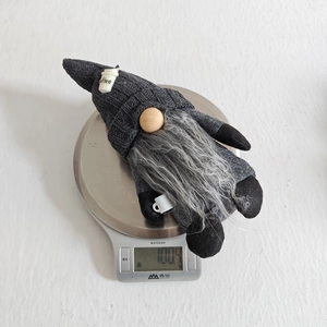 Close-up of a handmade coffee gnome figurine on a digital scale for precise weight measurement