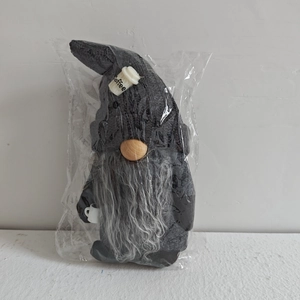 Close-up of a grey coffee gnome doll with a tall pointed hat and wooden nose detail
