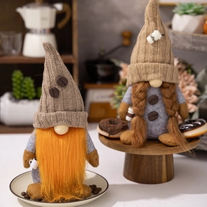 Detail of knitted coffee gnome plush with mini cup and bean accents for cafe decor