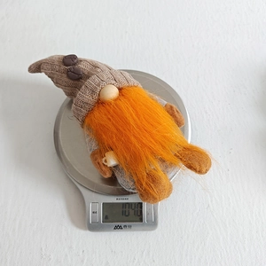 Detailed view of handmade coffee gnome gnome weighing 104g on a digital kitchen scale