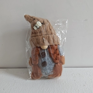 Detail of coffee gnome decor showing knitted hat with coffee cup and orange braids