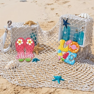 Close-up of summer beach themed welcome sign and LOVE wooden plaques on sand
