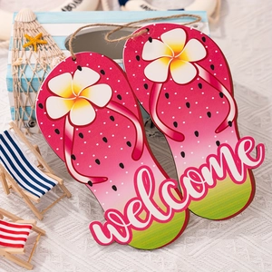 Detail of wooden flip-flop welcome sign with watermelon pattern and frangipani flower