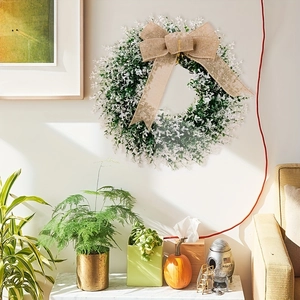 Artificial greenery wreath with white flowers and burlap bow for farmhouse front door