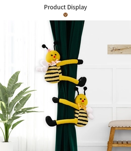 Detalle de alzapaños de abeja de peluche con rayas tejidas y alas en cortinas verdes