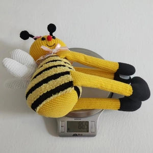 Vista detallada de abeja de peluche tejida a mano en una báscula digital de 86,5 gramos
