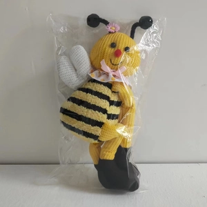 Detalle de abrazadera de cortina tejida a mano con diseño de abeja y lazo rosa