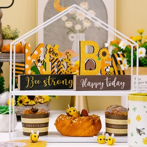 Close-up of rustic Bee Kind wooden tiered tray signs with sunflower and honey bee patterns