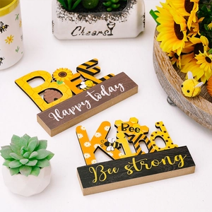 Detail view of bee-themed wooden tabletop signs with Happy Today and Bee Kind carvings