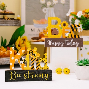 Detailed view of Bee Kind and Bee Strong wooden desk signs with daisy and honeybee patterns