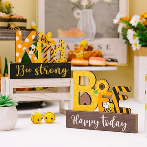 Macro detail of 'Bee Kind' and 'BEE' wooden desktop signs with sunflower sunflower accents