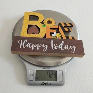 Detailed view of Bee wooden tabletop decor on a digital scale showing weight of 124g