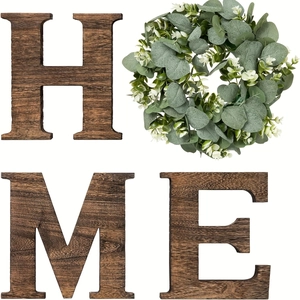 Close-up of rustic wood letters and eucalyptus wreath forming HOME wall decor