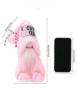 Gnome en peluche rose avec broderie Fight Cancer et ruban à côté d'un smartphone