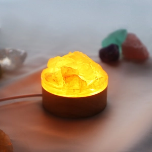Détail d'une lampe en cristal naturel à lueur chaude avec socle en bois et USB