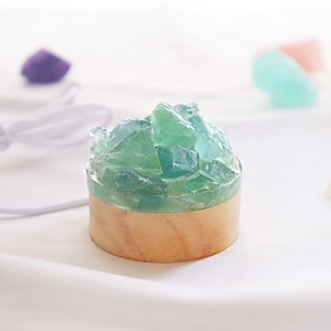 Gros plan de cristaux de fluorite verte naturelle sur socle en bois avec câble USB