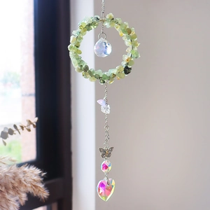 Detail van lichtgroene kristallen zonnevanger met vlinder en hartvormige hanger met AB-coating