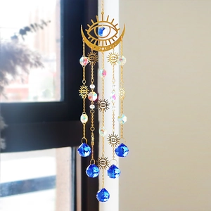 Detailed shot of bohemian suncatcher with evil eye metal charms and blue crystal teardrop