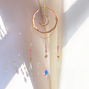 Macro shot of suncatcher detail with pink crystals and sun pendant reflecting rainbows