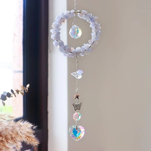 Detailopname van kristallen zonnevanger met blauwe stenen en hartvormige prisma hanger