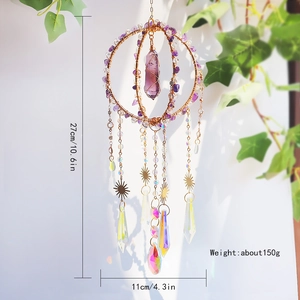 Detail of amethyst crystal suncatcher hanging with golden rings and vibrant rainbow prisms