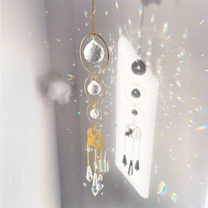 Golden cat suncatcher with crystal spheres creating rainbow light on white background