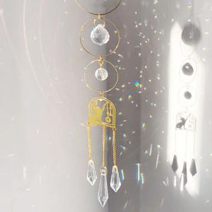 Golden suncatcher with cat silhouette and multifaceted crystal prisms for rainbow reflection