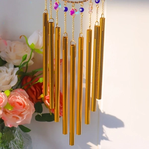Detail of 10 golden metal tubes with blue evil eye beads and crystal pendant decor