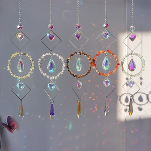 Five crystal suncatchers with natural stones casting rainbow light on a grey wall