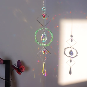 Detail view of crystal suncatcher featuring green natural stones and rainbow prism pendants