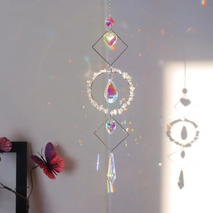 Detail of crystal suncatcher with natural stones reflecting rainbow light on a wall