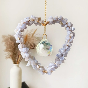 Detalle de atrapasol de corazón con cristales azules, prisma facetado y cadena dorada