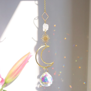Detail van gouden maan zonnevanger met kristallen bol en regenboog lichtreflecties