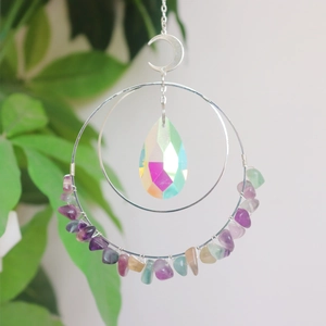 Detailed view of bohemian suncatcher with moon pendant and colorful crystals on silver chain